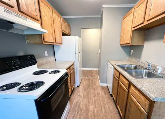 A kitchen with a white stove and a white refrigerator.