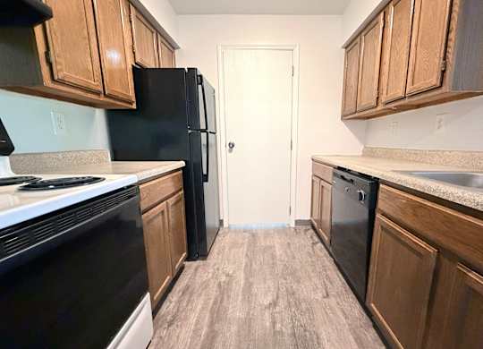 A kitchen with black appliances and wooden cabinets.