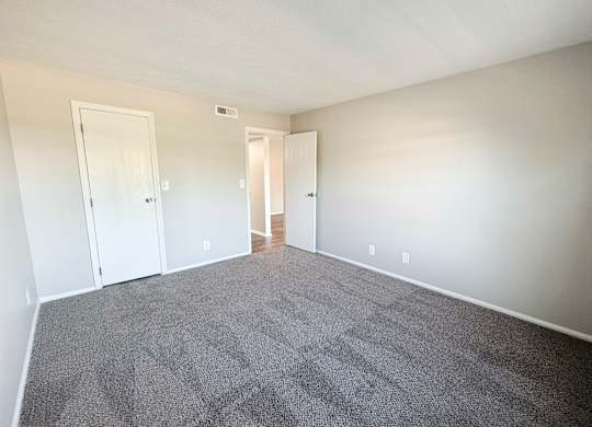 A room with grey carpet and white walls.