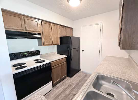 A kitchen with black appliances and wooden cabinets.