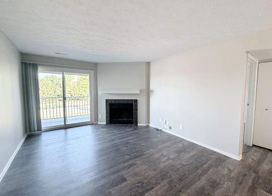 A room with a fireplace and sliding glass doors.