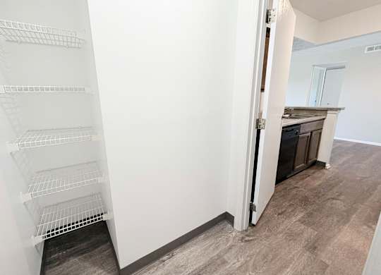 A white shelving unit in a room with a grey floor.