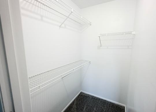 A white empty pantry with a black floor.