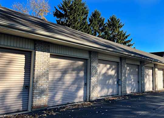 A long building with a grey roof and white garage doors.