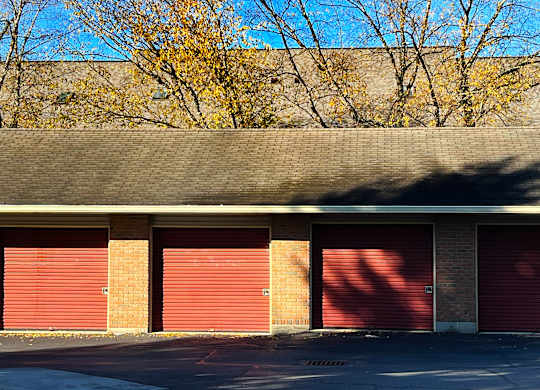 A building with red garage doors and a grey roof.