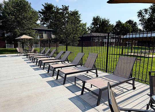 A row of sun loungers are on a concrete surface.