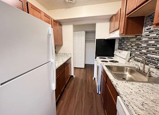 A kitchen with a white refrigerator and a white dishwasher.