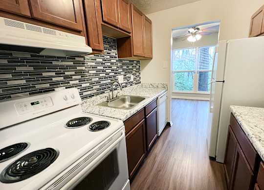 A kitchen with a white stove top oven and a white refrigerator.