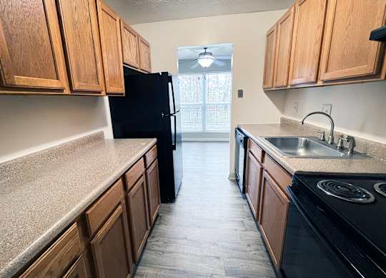 A kitchen with wooden cabinets and black appliances.
