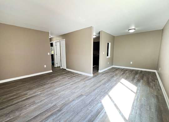 A room with wooden flooring and a white door.