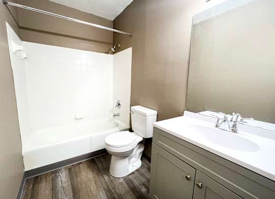 A white toilet sits next to a bathtub in a bathroom.