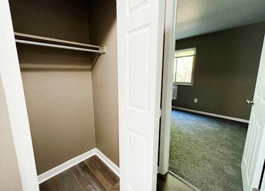 A white door is open to a room with a grey carpet.