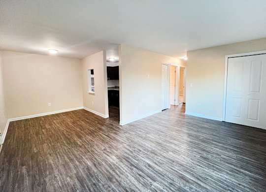A room with wooden flooring and white walls.