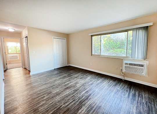 A room with a window and a wall-mounted air conditioner.