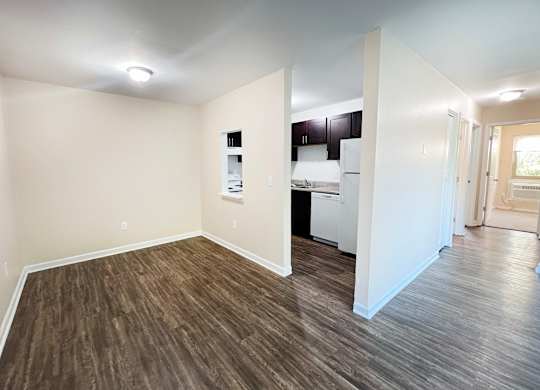 A room with wooden flooring and white walls.
