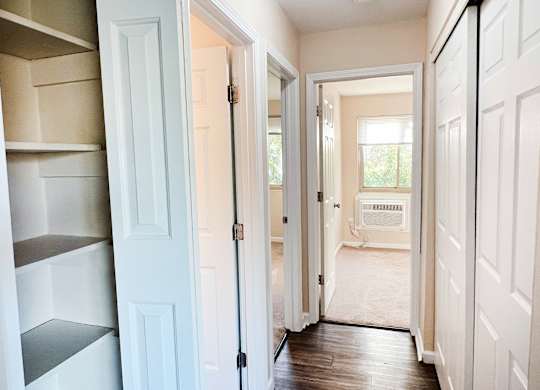 A hallway with white doors and a sign that says "Welcome".
