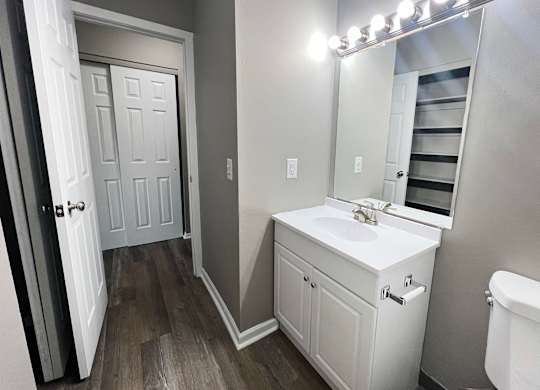 A white bathroom with a vanity and a white tub.