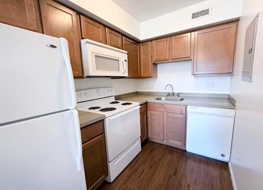 A kitchen with white appliances and wooden cabinets.