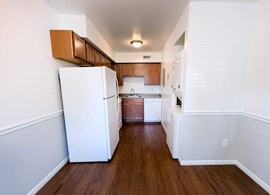 A kitchen with white appliances and wooden cabinets.