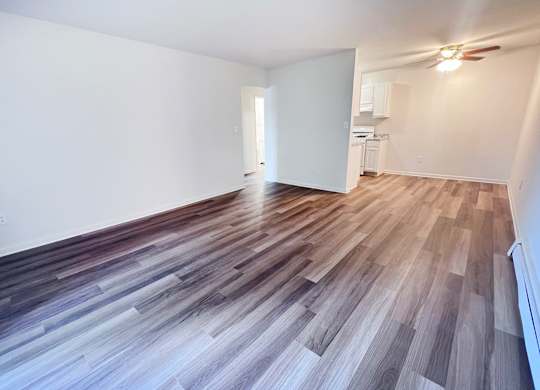 A room with wooden flooring and a white wall.
