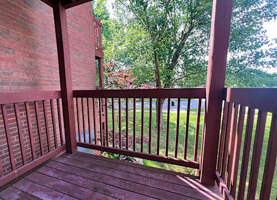 A wooden deck with a red brick building in the background.