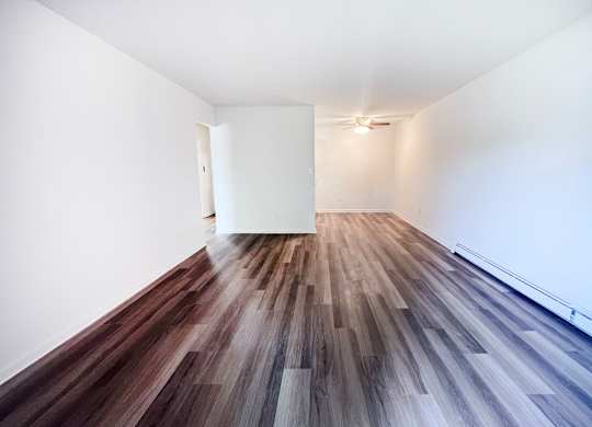 A room with a white wall and a wooden floor.
