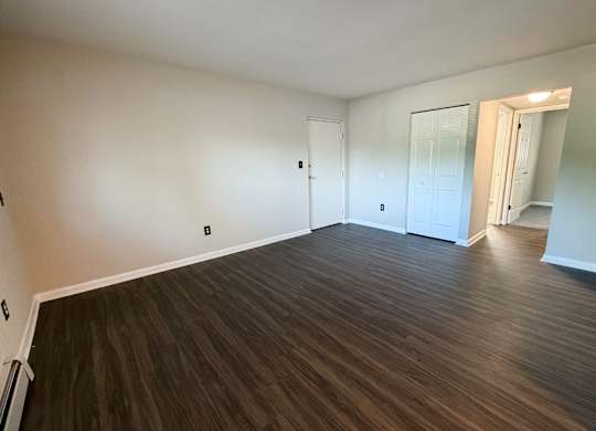 A room with wooden flooring and white walls.