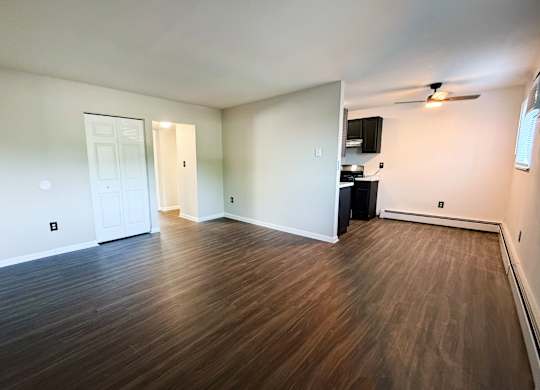 A room with wooden flooring and a ceiling fan.