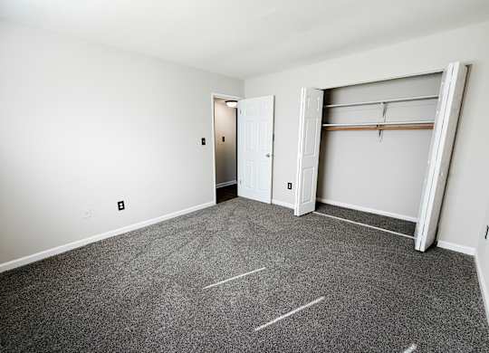 A room with a grey carpet and a white door.