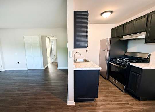 A kitchen with black cabinets and a white countertop.