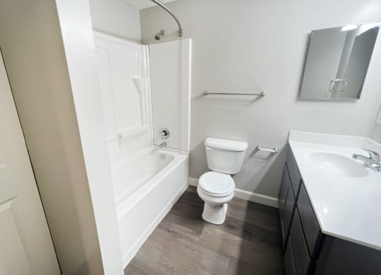 a bathroom with a toilet and a tub and a sink at Woodhills Apartments, West Carrollton