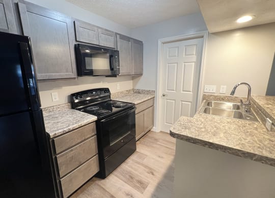 a kitchen with black appliances and granite counter tops at Woodhills Apartments, Ohio, 45449