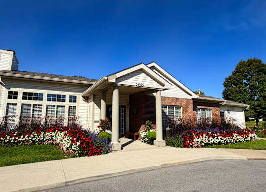 A house with a white front porch and a flower bed in front.