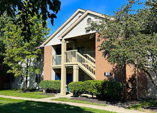 A brick building with a balcony and a sign that says