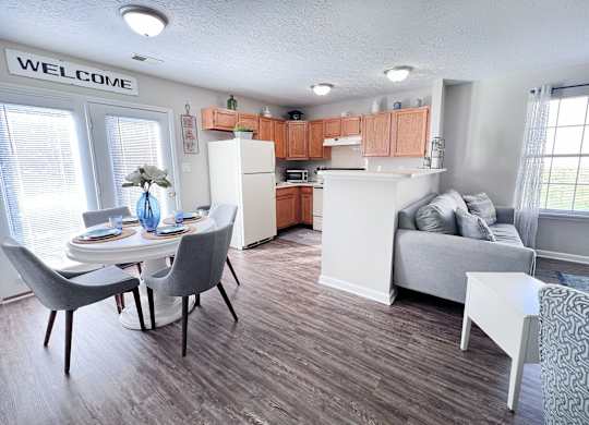 A kitchen with a dining table and chairs.