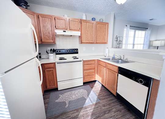 A kitchen with wooden cabinets and a white fridge.