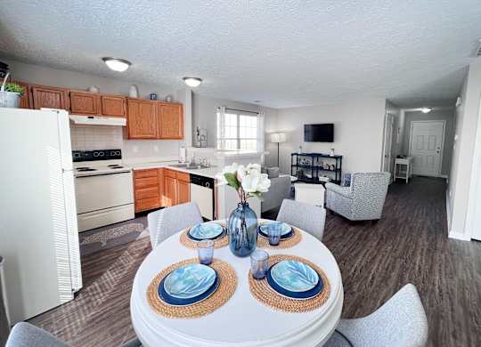 A well-lit kitchen with a dining table set for two.