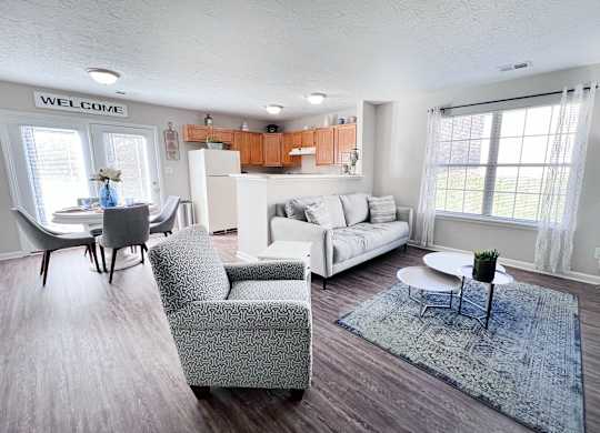 A living room with a sofa, chairs, and a rug.