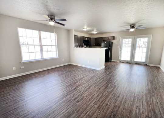 A room with wooden flooring and a ceiling fan.