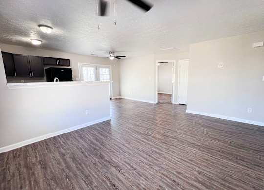 A room with wooden flooring and a ceiling fan.