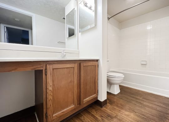 a bathroom with a toilet and a sink and a mirror at Deercross in Blue Ash, OH