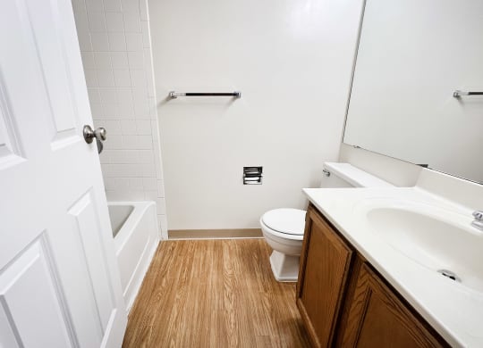 an empty bathroom with a toilet and a sink  at Deercross Apartments, Ohio