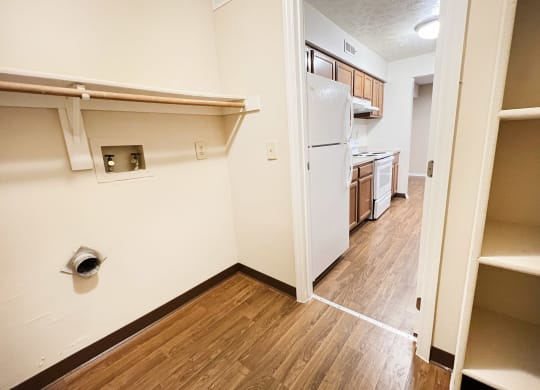 a view of a kitchen and a hallway with wood flooring and a white refrigerator  at Deercross Apartments, Cincinnati