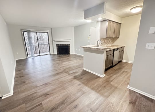 an empty living room with a kitchen and a fireplace  at Deercross Apartments, Cincinnati, 45236
