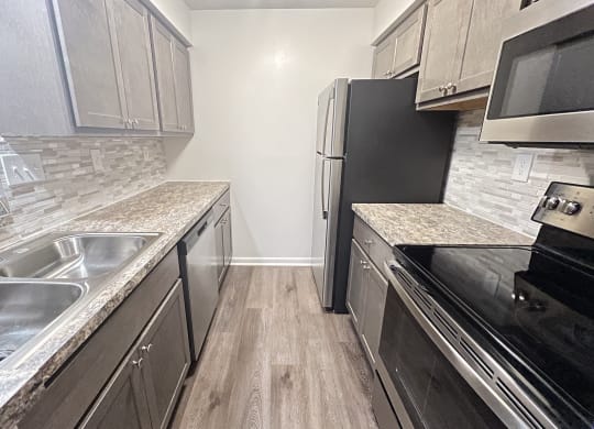 a kitchen with stainless steel appliances and marble counter tops  at Deercross Apartments, Cincinnati, OH, 45236