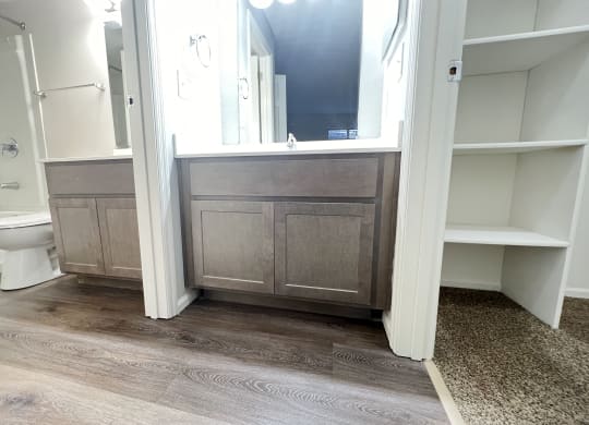a bathroom with a toilet and a vanity with a mirror  at Deercross Apartments, Cincinnati