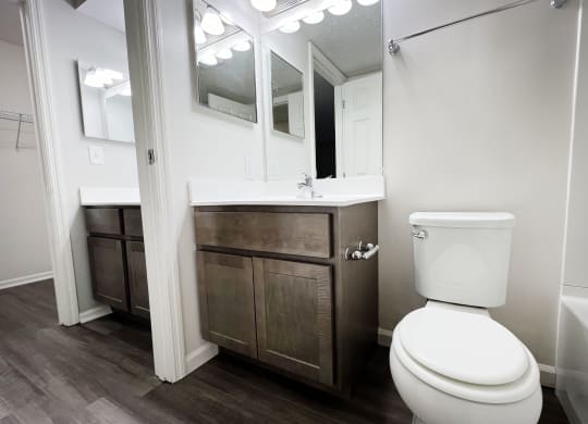 a bathroom with a toilet and a sink and a mirror  at Deercross Apartments, Cincinnati, OH, 45236