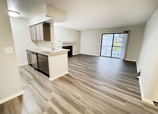 an empty living room and kitchen with wood flooring  at Deercross Apartments, Ohio