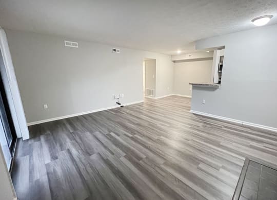 the living room and dining room of an apartment with wood flooring  at Deercross Apartments, Ohio
