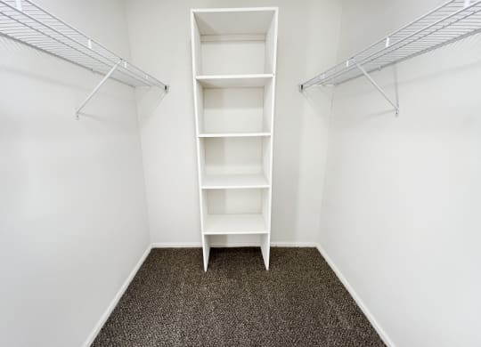 an empty closet in a room with white walls and shelves  at Deercross Apartments, Cincinnati